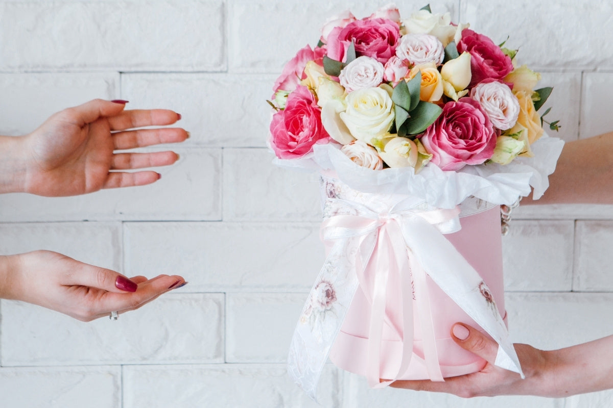 hands outstretched to receive a flower delivery