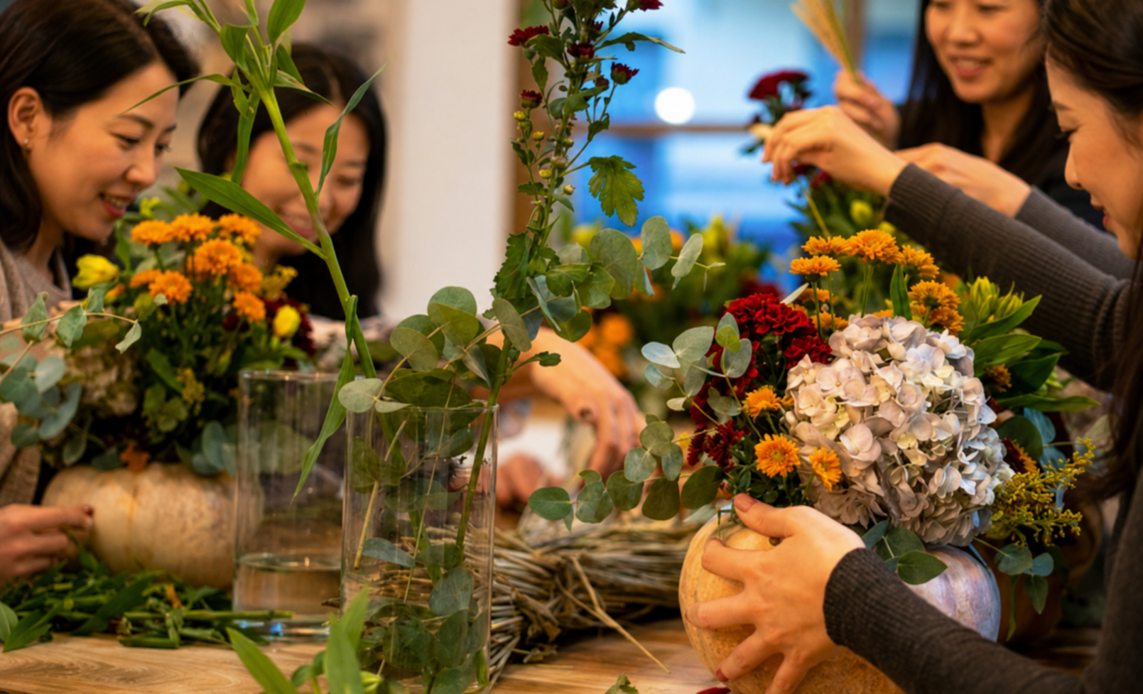 Corporate flower arrangement workshop with Asian participants creating floral centrepieces together, showcasing a creative team bonding activity in Singapore.