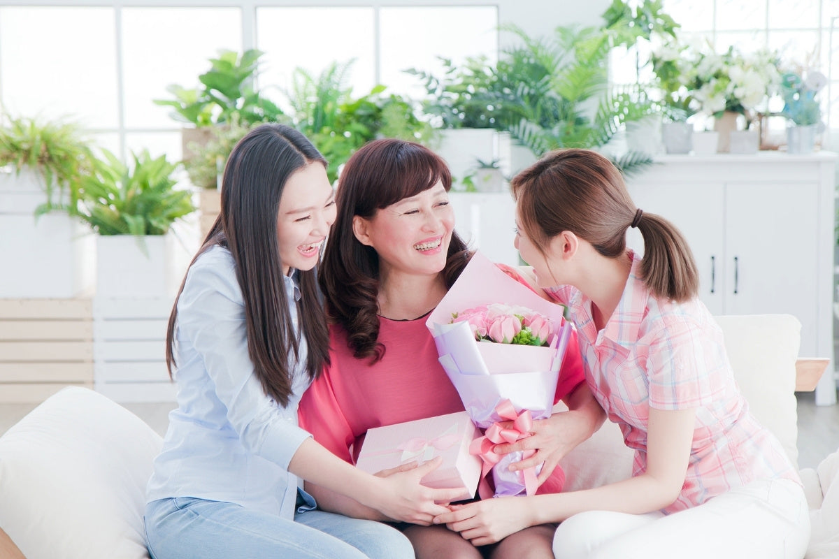 Daughters Giving Flowers and Gift to Mom for Mother's Day