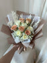 Savannah bouquet with cappuccino and white roses paired with baby's breath