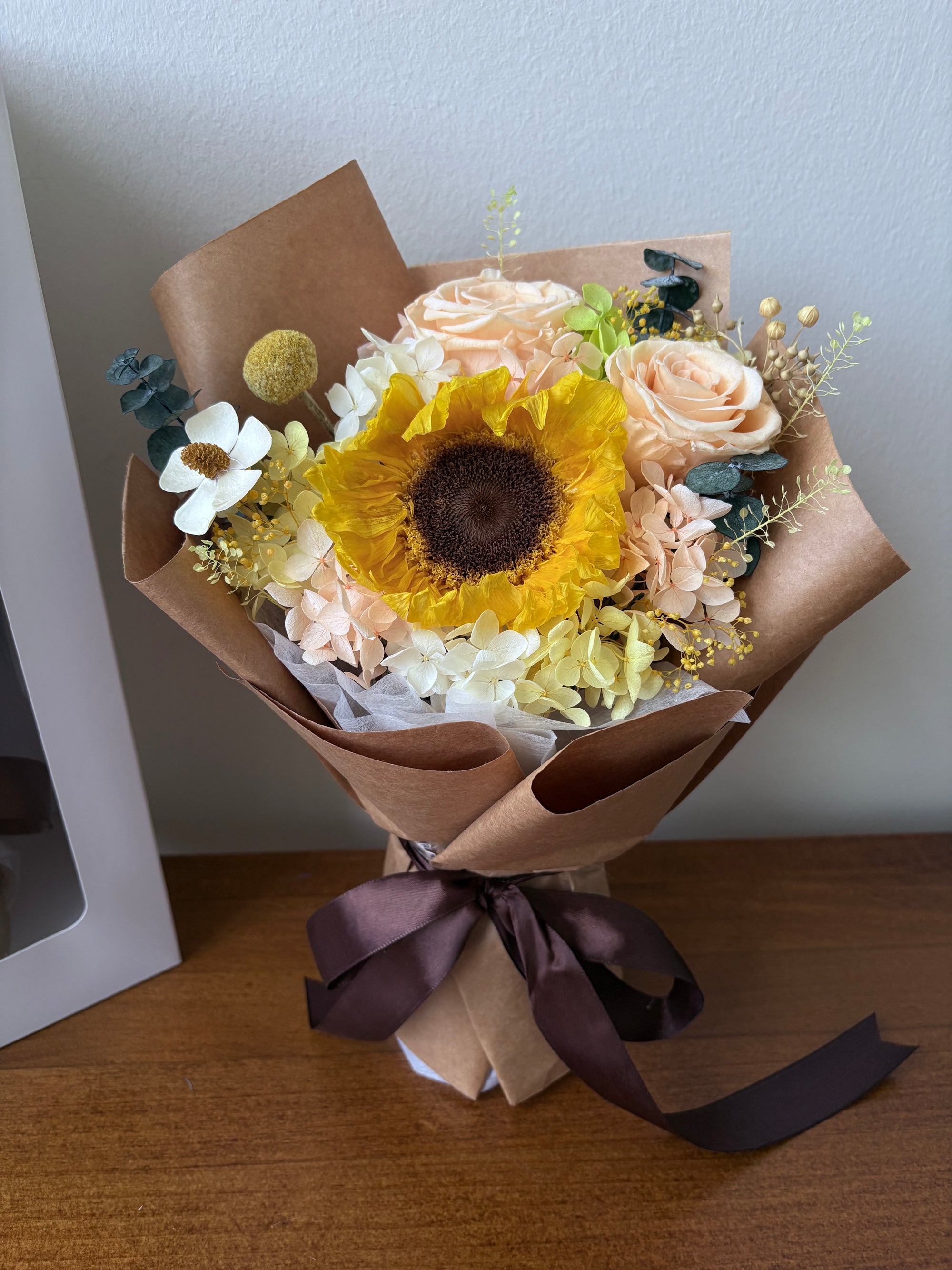 Bouquet of flowers with a sunflower on a wooden surface