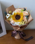 Bouquet of flowers with a sunflower on a wooden surface