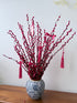 Decorative branch with red ribbons and tassels on a white background