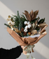 Forest Noel Christmas arrangement with seasonal foliage and soft festive blooms